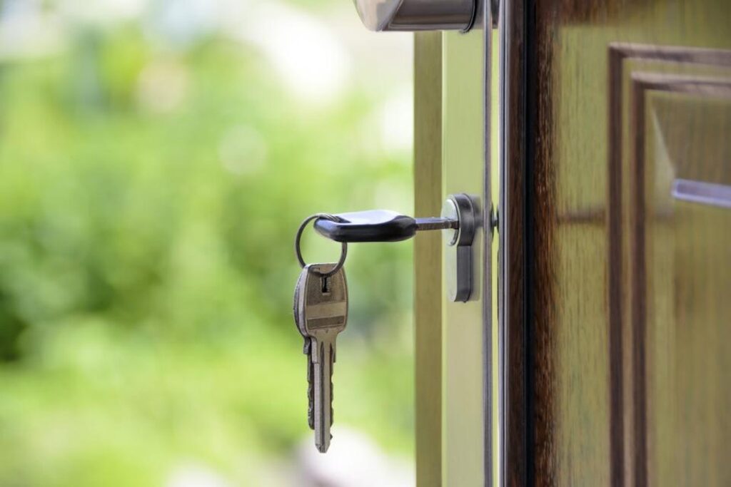 Llaves junto a una puerta, en relación con la venta de una casa y el pago del ISR.