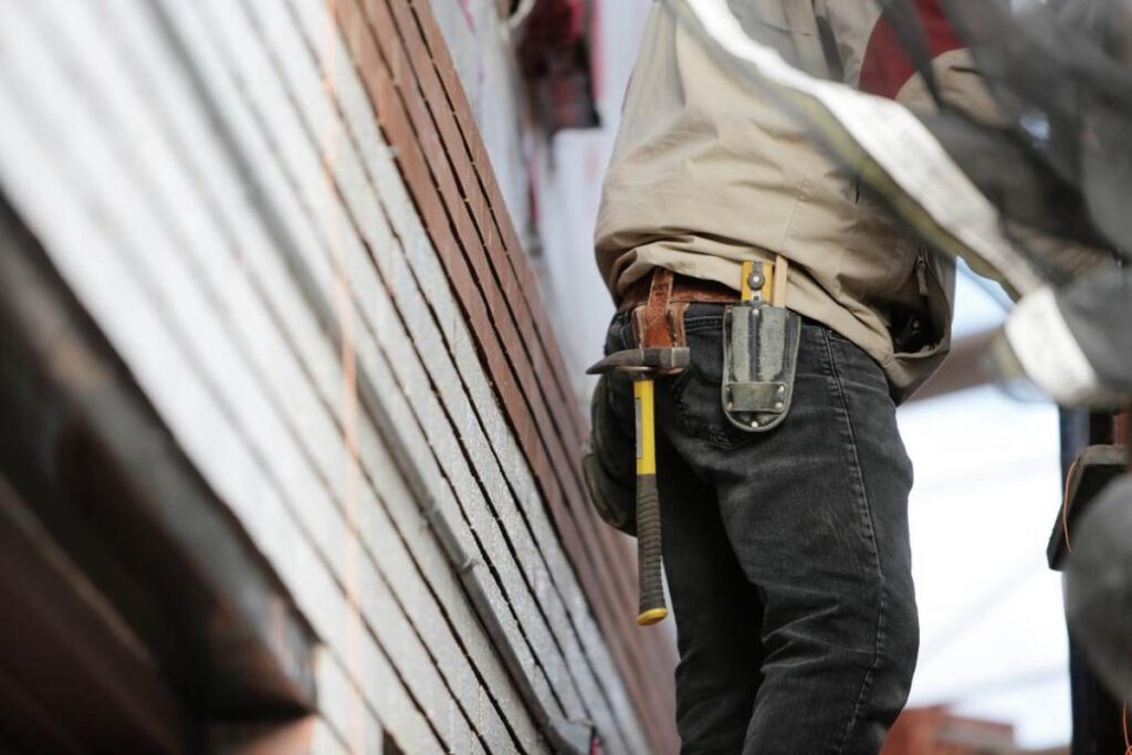 Trabajador con casco en una obra, en relación con el outsourcing y la subcontratación.