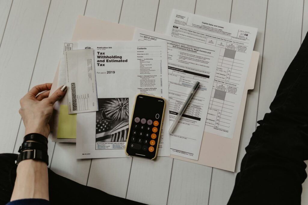 Papeles de trabajo contables y calculadora sobre escritorio para amortización de pérdidas fiscales